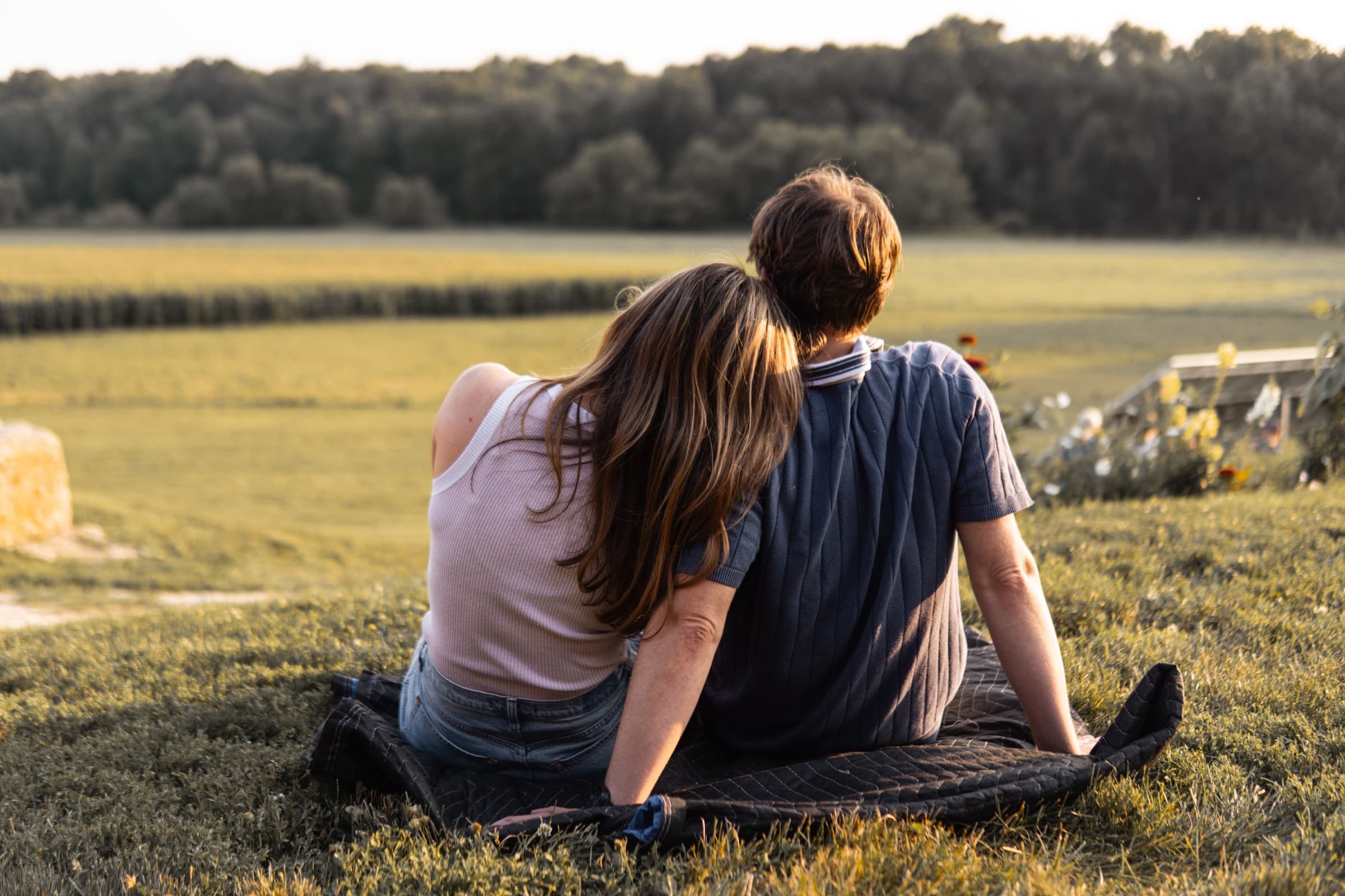 Jens and Christina sitting together in a sunlit field